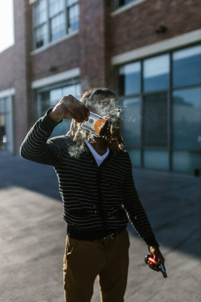 man burning money on a street
